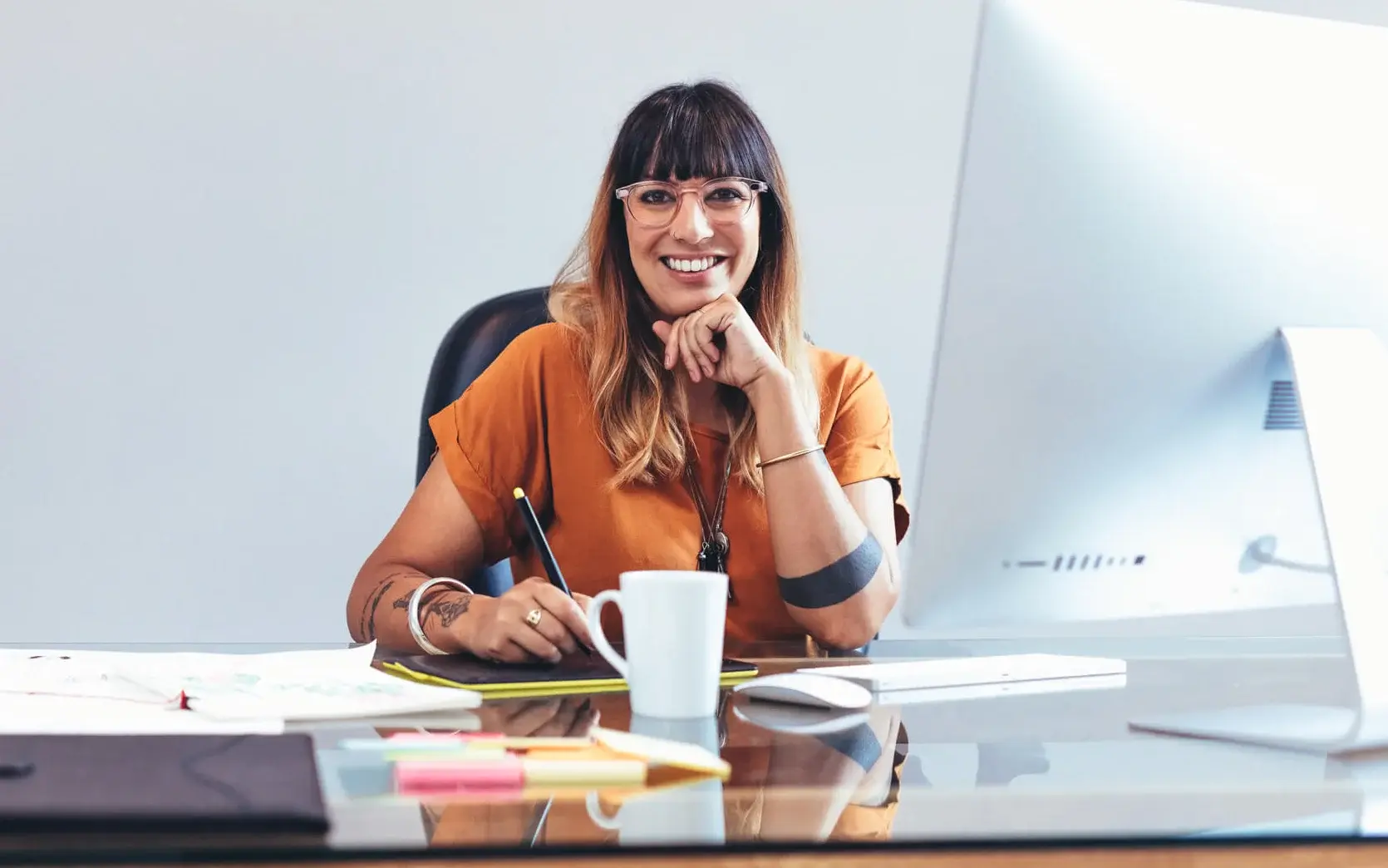 Happy women sitting at desk after securing small business financing. 