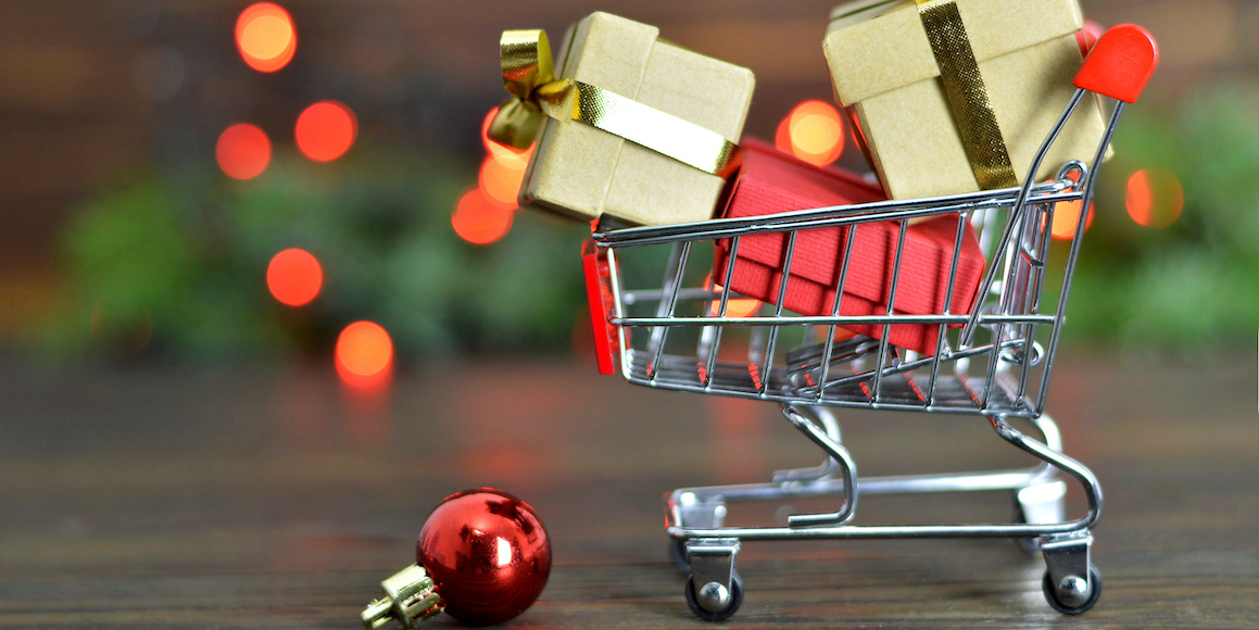 Tiny shopping cart filled with gifts that were purchased using holiday budgeting tips