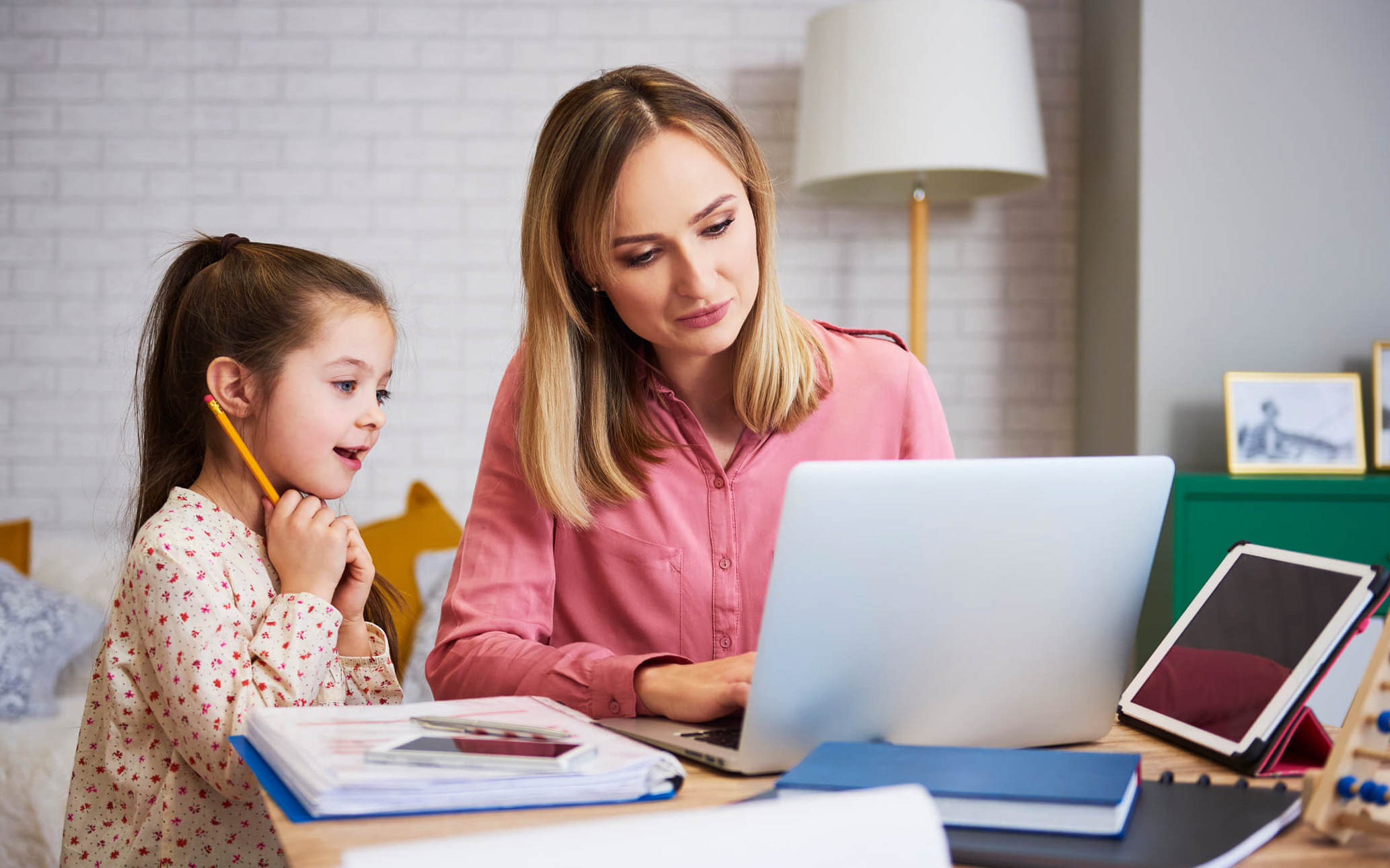 Mother and daughter looking at a laptop learning keys to maximize saving money on back-to-school shopping