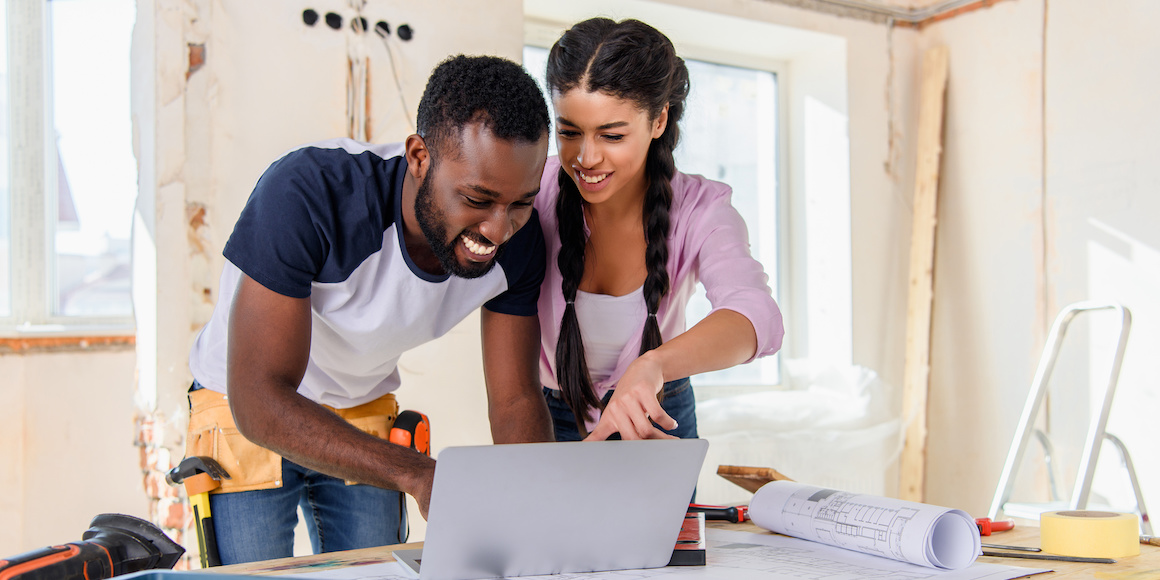 Young couple smiling in their home as they discuss financing for a home renovation.