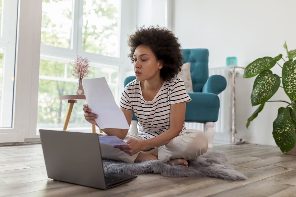 Woman on laptop working on improving her credit score before she applies for a home loan. 